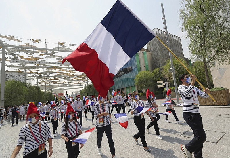 Marchers wave the French and Emirati flags during the French ceremonial day at the Dubai Expo 2020 in Dubai, United Arab Emirates, Saturday, Oct, 2, 2021. (AP Photo/Kamran Jebreili)