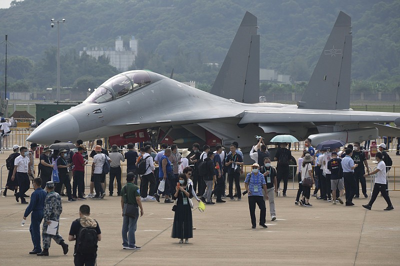 Visitors look at the Chinese military's J-16D electronic warfare airplane during 13th China International Aviation and Aerospace Exhibition, also known as Airshow China 2021, on Wednesday, Sept. 29, 2021, in Zhuhai in southern China's Guangdong province. The ruling Communist Party is pouring billions of dollars into developing fighter jets, stealth technology, drones and other hardware for its military wing, the People's Liberation Army, as it presses claims to disputed seas and other territory. (AP Photo/Ng Han Guan)