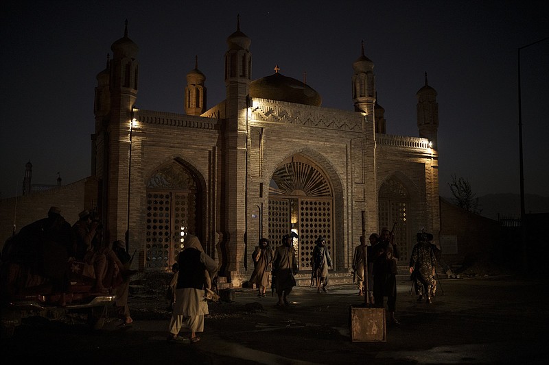 Taliban fighters walk at the entrance of the Eidgah Mosque after an explosion in Kabul, Afghanistan, Sunday, Oct. 3, 2021. A bomb exploded in the entrance of the mosque in the Afghan capital on Sunday leaving a &quot;number of civilians dead,&quot; a Taliban spokesman said. (AP Photo/Felipe Dana)