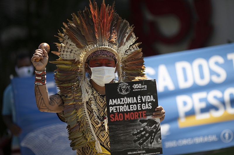 FILE- In this Dec.4, 2020 file photo, Ninawa Inu Huni kui protests against auctions for the exploration of oil fields in the Amazons outside an hotel in Rio de Janeiro, Brazil. A Brazilian Indigenous leader is appealing to France's president to use his sway to fight deforestation of the Amazon. The leader, Ninawa, of the Huni Kui people, delivered a letter to the office of French President Emmanuel Macron on Saturday. (AP Photo/Silvia Izquierdo, File)