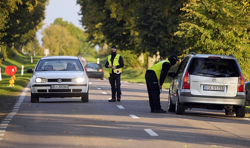 Polish police officers stop cars going in and out of an area along the border with Belarus, where a state of emergency is in place, in Krynki, Poland, Wednesday Sept. 29, 2021. European Union members Poland and Lithuania are struggling to cope with an unusually high number of migrants, most from Iraq and Afghanistan, arriving at their borders with Belarus in recent months. Poland has deployed troops and declared a state of emergency, and accuses Belarus of waging a &quot;hybrid war&quot; against the EU. (AP Photo/Czarek Sokolowski)