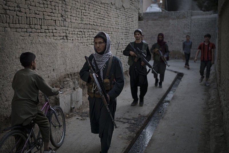 Taliban fighters patrol a neighborhood in search for a man accused in a stabbing incident, in Kabul, Afghanistan, Sunday, Sept. 12, 2021. The Taliban are promising a return of some of their harsh punishments that made them notorious. That has many Afghans afraid, but some also say they are giving the Taliban a chance if it means greater stability and fewer corrupt officials reaching into their pockets. (AP Photo/Felipe Dana)