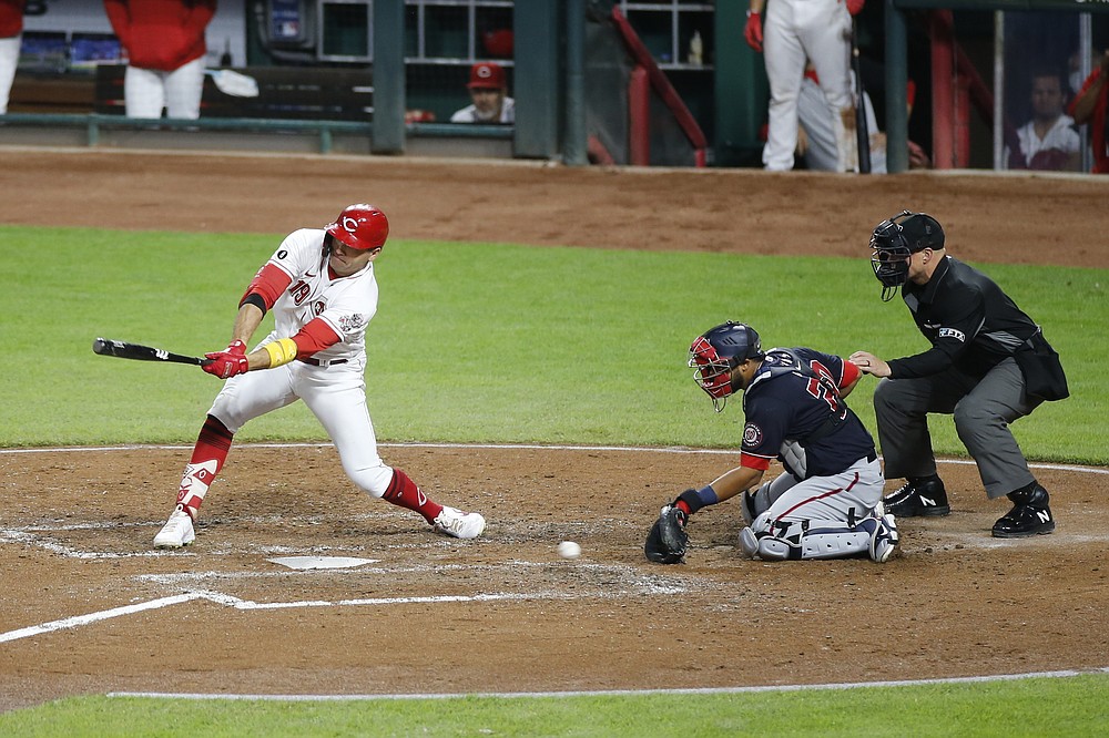 Joey Votto of the Cincinnati Reds, left, hits with loaded bases in the fifth inning of a baseball game against the Washington Nationals on Thursday, September 23, 2021, in Cincinnati. (AP Photo / Jay LaPrète)
