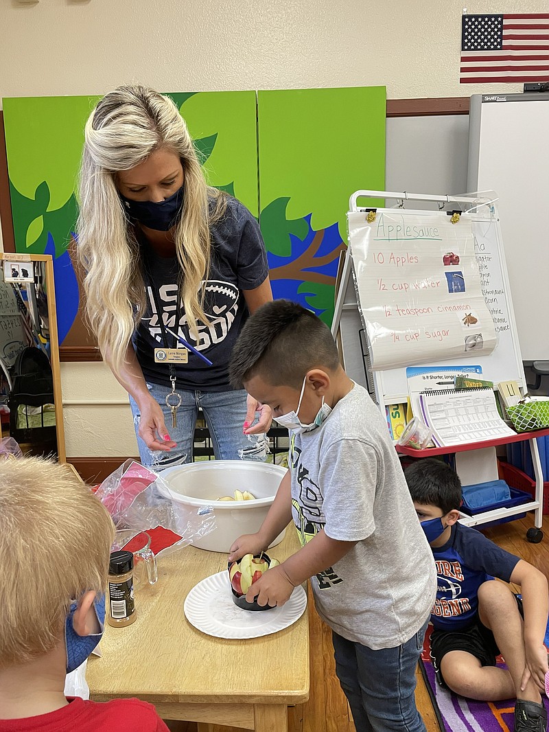 Jacob Rojas, right, helps his teacher, Carrie Morgan, slice apples. - Submitted photo