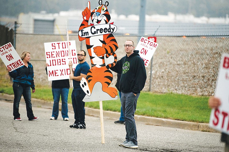 First shift worker Travis Huffman joins other BCTGM Local 3G union members Tuesday in a strike against Kellogg Co. outside the Kellogg plant on Porter Street in Battle Creek, Mich. Workers in Battle Creek, Lancaster, Memphis and Omaha walked out at 1 a.m. Tuesday, demanding livable wages and better benefits. (Associated Press)