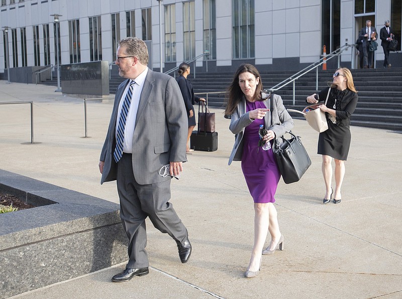 Attorneys and staff associated with a federal trial of pharmacies, CVS, Walgreens, Giant Eagle and Walmart, leave the Carl B. Stokes Federal Courthouse in Cleveland, Monday, Oct. 4, 2021. The pharmacies are being sued by Ohio counties Lake and Trumbull for their part in the opioid crisis. (AP Photo/Phil Long)