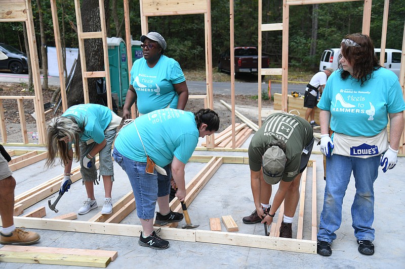 Volunteers participate in Habitat for Humanity’s Heels to Hammers women’s build on Wednesday, the second day of their five-day project. - Photo by Tanner Newton of The Sentinel-Record