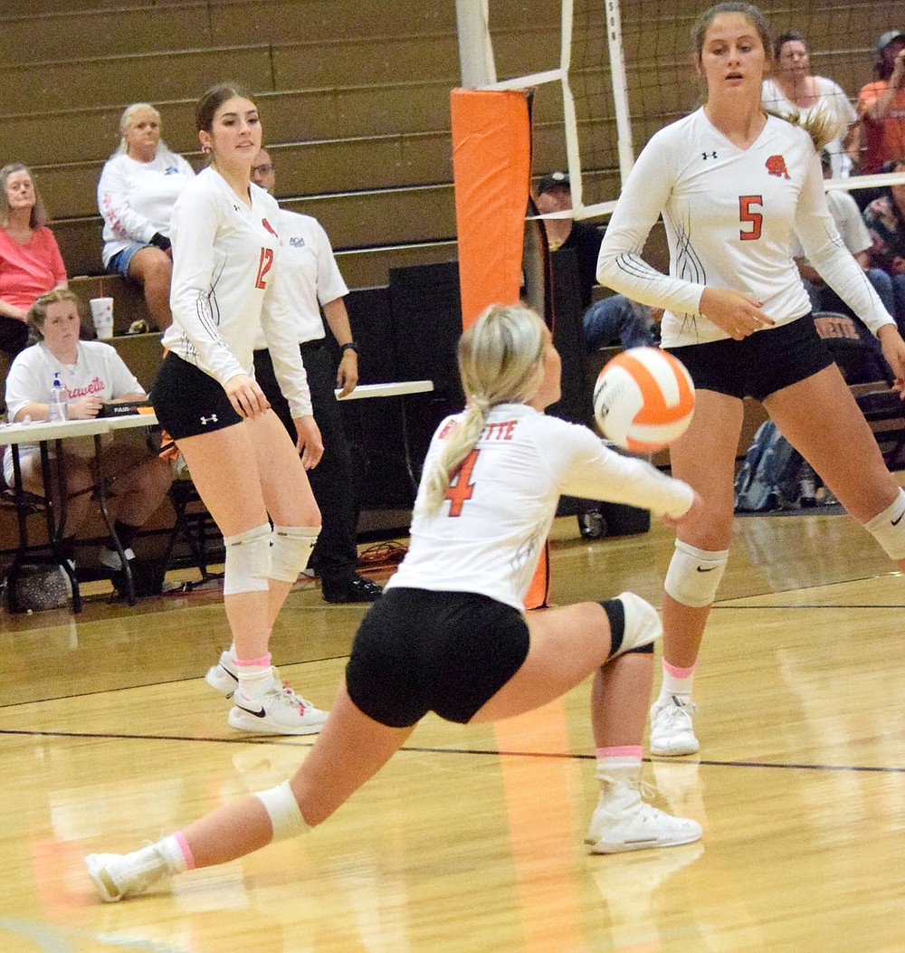 Westside Eagle Observer/MIKE ECKELS
Lady Lion Layne Franks (4) gets on one knee in order to reach a low ball during the Thursday night Gravette-Gentry volleyball match in the Competition Gym in Gravette. Franks managed to hit the ball back over the net and into Lady Pioneer territory.