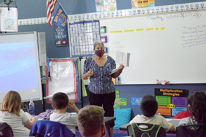 Westside Eagle Observer/MIKE ECKELS
Karen McAuley demonstrates the proper way to use a dictionary to Leslie Thompson's third grade class at Northside Elementary in Decatur Sept. 30.  McAuley's organization, Altrusa International of Benton County, handed out dictionaries to both third grade classes at Northside as a reference guide for future studies.