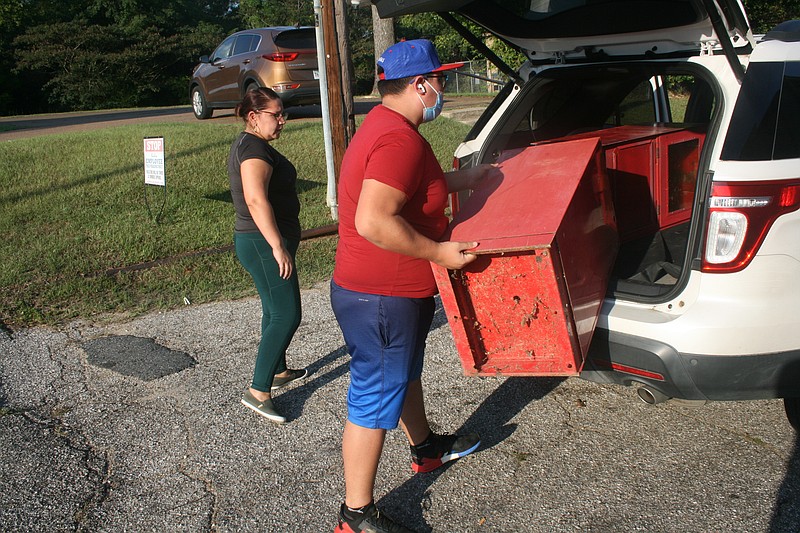 Miranda Risinger and Cristopher Hernandez pick up newsstands donated by the News-Times to use as Blessing Boxes. The first is set to hit the streets before the end of the year; it will be filled with food, clothing and household and school supplies for anyone who needs them. (Matt Hutcheson/News-Times)