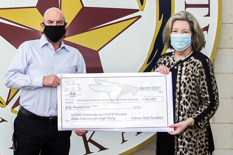 Ron Mills, BancorpSouth senior vice president and regional manager, presents a $25,000 check from the Wayne Garrison Trust to Texas A&M-Texarkana President Emily Cutrer. The donation will be used to fund scholarships for students. Photo courtesy Texas A&M University-Texarkana