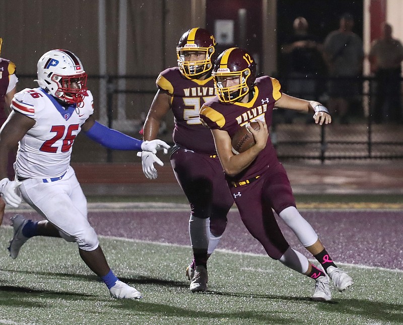 Lake Hamilton's Tevin Hughes (25) watches Grant Bearden (12) run the ball as Little Rock Parkview's Benjamin Allen (26) defends during an Oct. 1 game at Lake Hamilton. The Wolves host Russellville tonight at 7 p.m. - Photo by Richard Rasmussen of The Sentinel-Record