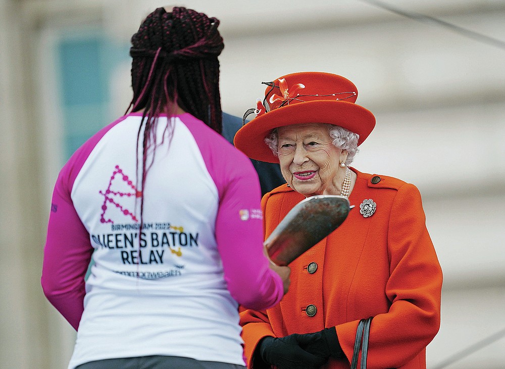 Britain's Queen Elizabeth II talks to the first baton bearer, British parasport athlete Kadeena Cox, at the launch of the Queen's Baton Relay for Birmingham 2022 - the XXII Commonwealth Games, on the forecourt of Buckingham Palace in London, Thursday, Oct. 7, 2021. (Victoria Jones/Pool Photo via AP)