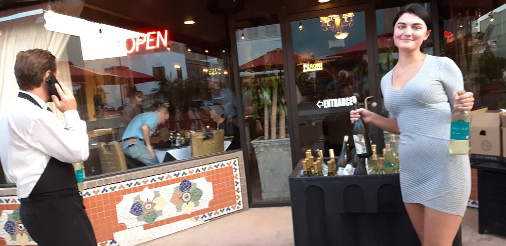 Staff photo by Junius Stone Jasie Perry, right, and Paul Verona set up an outdoor wine display and prepare the food for outdoor diners at Verona’s, as part in Destination Downtown on Friday night.