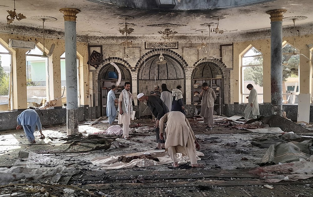 People view the damage inside of a mosque following a bombing in Kunduz, province northern Afghanistan, Friday, Oct. 8, 2021. A powerful explosion in the mosque frequented by a Muslim religious minority in northern Afghanistan on Friday has left several casualties, witnesses and the Taliban's spokesman said. (AP Photo/Abdullah Sahil)