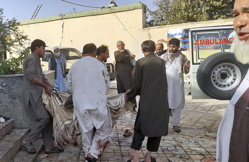 People carry the body of a victim following a bombing in Kunduz province, northern Afghanistan, Friday, Oct. 8, 2021. A powerful explosion in a mosque frequented by a Muslim religious minority in northern Afghanistan on Friday has left several casualties, witnesses and the Taliban's spokesman said. (AP Photo/Abdullah Sahil)