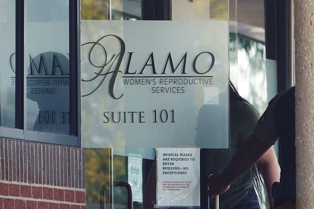 A woman enters Alamo Women's Reproductive Services, Thursday, Oct. 7, 2021, in San Antonio. A federal judge ordered Texas to suspend the most restrictive abortion law in the U.S., calling it an "offensive deprivation" of a constitutional right by banning most abortions in the nation's second-most populous state since September, but abortion services in Texas might not instantly resume even with the law on hold because doctors still fear that they could be sued without a more permanent legal decision. (AP Photo/Eric Gay)
