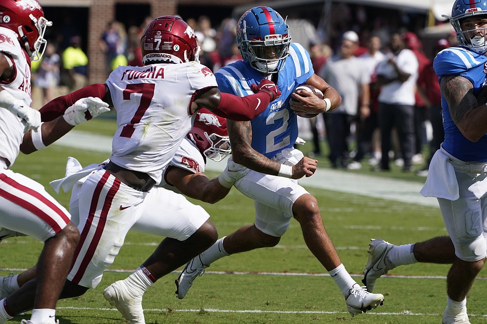 Mississippi quarterback Matt Corral (2) runs for a first down while being pursued by Arkansas defensive back Joe Foucha (7) during the first half of an NCAA college football game against Arkansas, Saturday, Oct. 9, 2021, in Oxford, Miss. (AP Photo/Rogelio V. Solis)