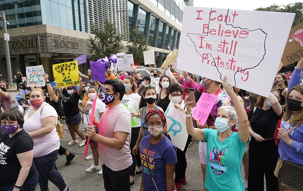 FILE - In this Oct. 2, 2021 file photo people participate in the Houston Women's March against Texas abortion ban walk from Discovery Green to City Hall in Houston. A federal appeals court is temporarily allowing the nation’s toughest abortion law to resume in Texas. The 5th U.S. Circuit Court of Appeals handed down the order Friday, Oct. 8. (Melissa Phillip/Houston Chronicle via AP, File)