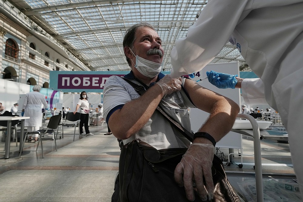 FILE - In this July 12, 2021, file photo, a medical worker administers a shot of Russia's Sputnik V coronavirus vaccine at a vaccination center in Gostinny Dvor, a huge exhibition place in Moscow, Russia. Russians are flocking to Serbia to receive Western-approved COVID-19 shots. Although Russia has its own vaccine known as Sputnik V, the shot has not been approved by international health authorities. (AP Photo/Pavel Golovkin, File)
