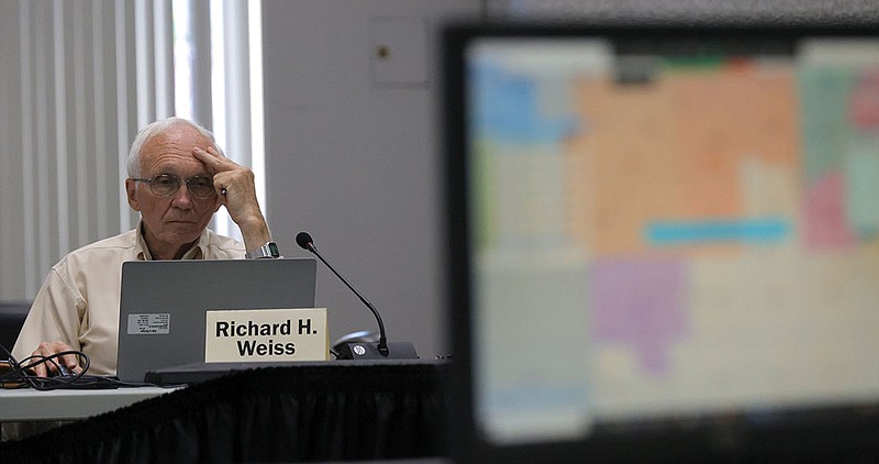 Richard Weiss studies a new map being talked about during the Michigan Independent Citizens Redistricting Commission meeting at Cadillac Place in Detroit, Wednesday, Sept. 1, 2021. The commission met to talk about and work with mapping consultants on drawing lines for various voting districts in the state of Michigan. (Eric Seals/Detroit Free Press via AP)