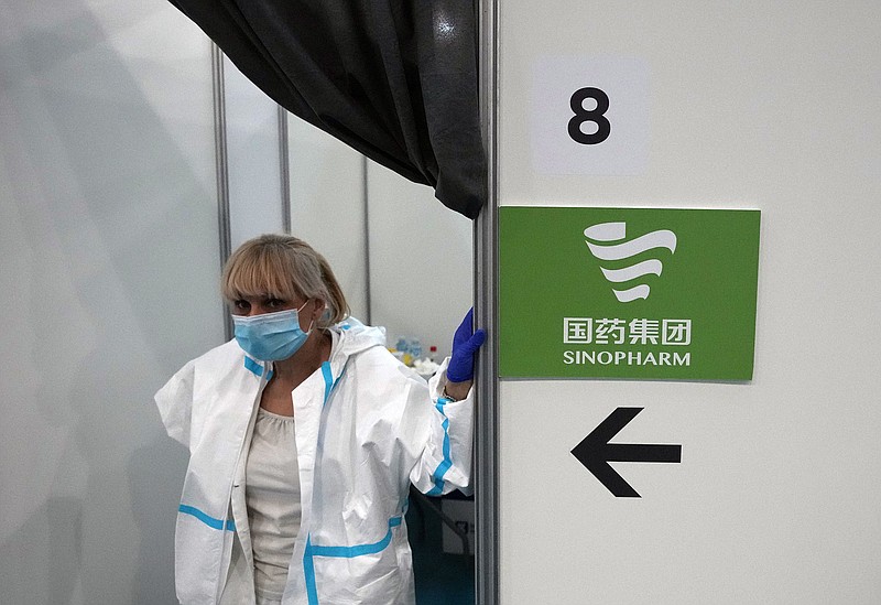 A medical worker wearing protective gear, waits for patients to receive the COVID-19 vaccine at Belgrade Fair makeshift vaccination center in Belgrade, Serbia, Saturday, Oct. 2, 2021. (AP Photo/Darko Vojinovic)