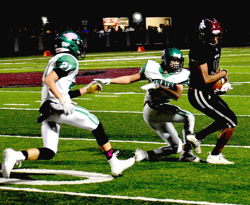 MARK HUMPHREY  ENTERPRISE-LEADER/Lincoln senior wide receiver A.J. Garner spins away from a Greenland defender who tried to steal his pass reception. Garner won the wrestling match over the football and the Wolves won 32-14 to celebrate Homecoming win Friday.