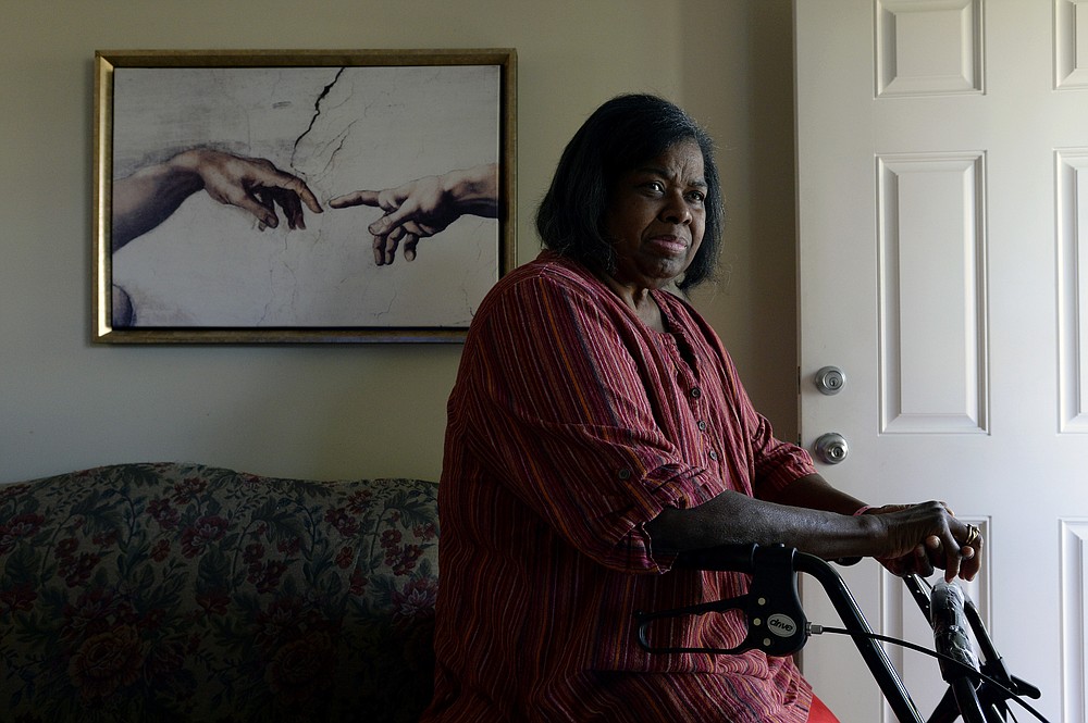 Debra Smith, 57, who has health problems that prevent her from working, rests on a walker near her front door on Thursday, Oct. 7, 2021, in Spring Hill, Tenn. Smith has about $10,000 in unpaid medical bills. Patient advocates and some state governments say hospitals must do more to help patients deal with medical bills before the debt winds up in collections. (AP Photo/Mark Zaleski)