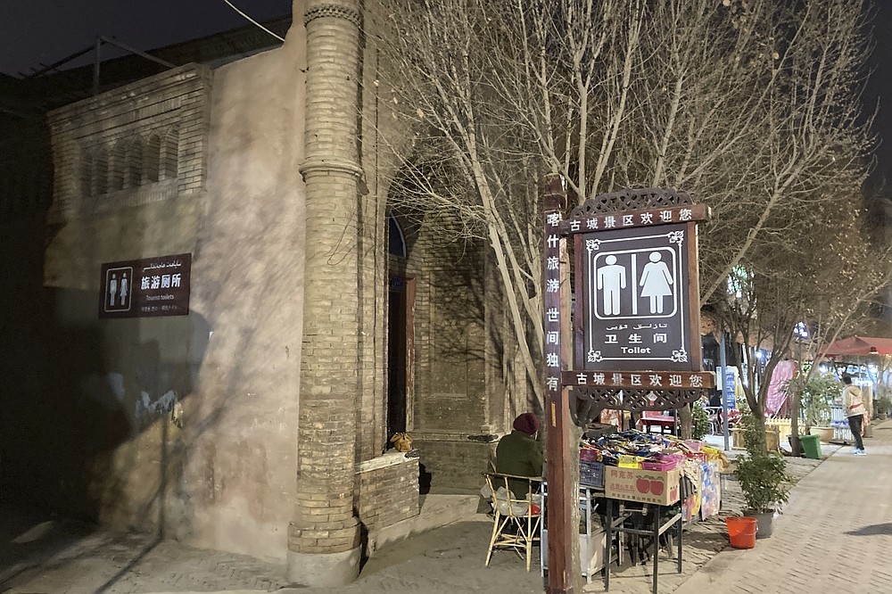 Vendors sell their goods by a section of a mosque converted into a tourist bathroom in Kashgar, in China's far west Xinjiang region, on March 19, 2021. Four years after Beijing's brutal crackdown on largely Muslim minorities native to Xinjiang, Chinese authorities are dialing back the region's high-tech police state and stepping up tourism. But even as a sense of normality returns, fear remains, hidden but pervasive. (AP Photo/Dake Kang)