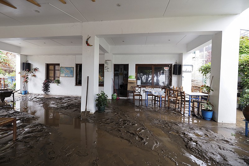 Mud covers the yard of a restaurant at Achladi village following a flood on the northern part of Evia island, Greece, Sunday, Oct. 10, 2021. The wildfires that destroyed a third of the island's forests in early August have loosened the topsoil and several communities are at risk from flooding. (AP Photo/Thodoris Nikolaou)