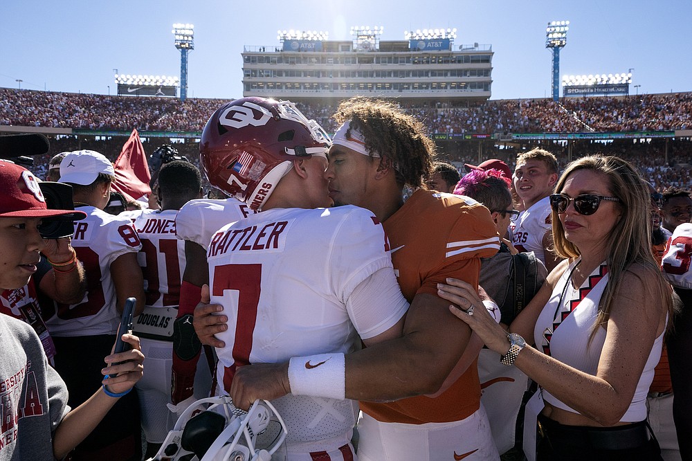 Oklahoma quarterback Spencer Rattler hugs Texas quarterback Casey Thompson after Oklahoma beat Texas in an NCAA college football game at the Cotton Bowl, Saturday, Oct. 9, 2021, in Dallas. (AP Photo/Jeffrey McWhorter)