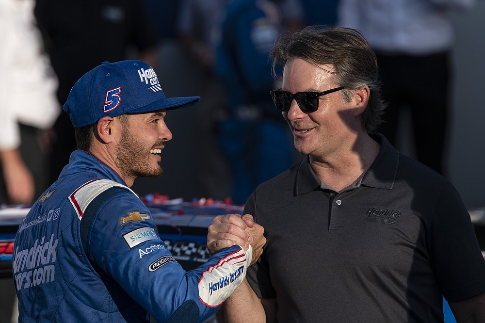 Kyle Larson, left, and Jeff Gordon shake hands in Victory Lane after a NASCAR Cup Series auto racing race at Charlotte Motor Speedway, Sunday, Oct. 10, 2021, in Concord, N.C. (AP Photo/Matt Kelley)