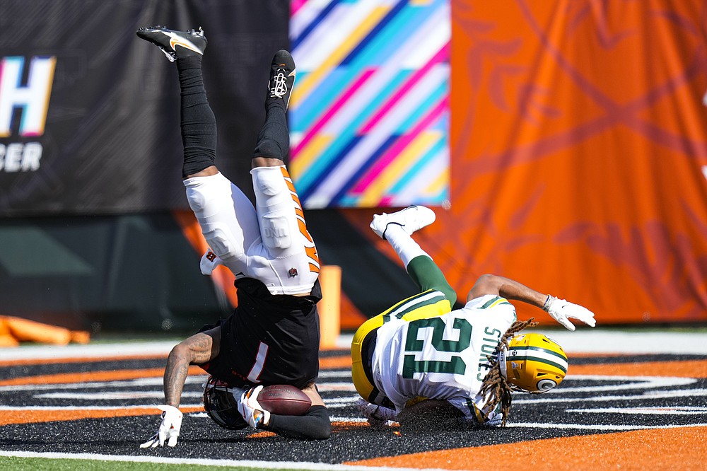 Cincinnati Bengals wide receiver Ja'Marr Chase (1) flips into the end zone for a touchdown as he's hit by Green Bay Packers cornerback Eric Stokes (21) in the second half of an NFL football game in Cincinnati, Sunday, Oct. 10, 2021. (AP Photo/AJ Mast)