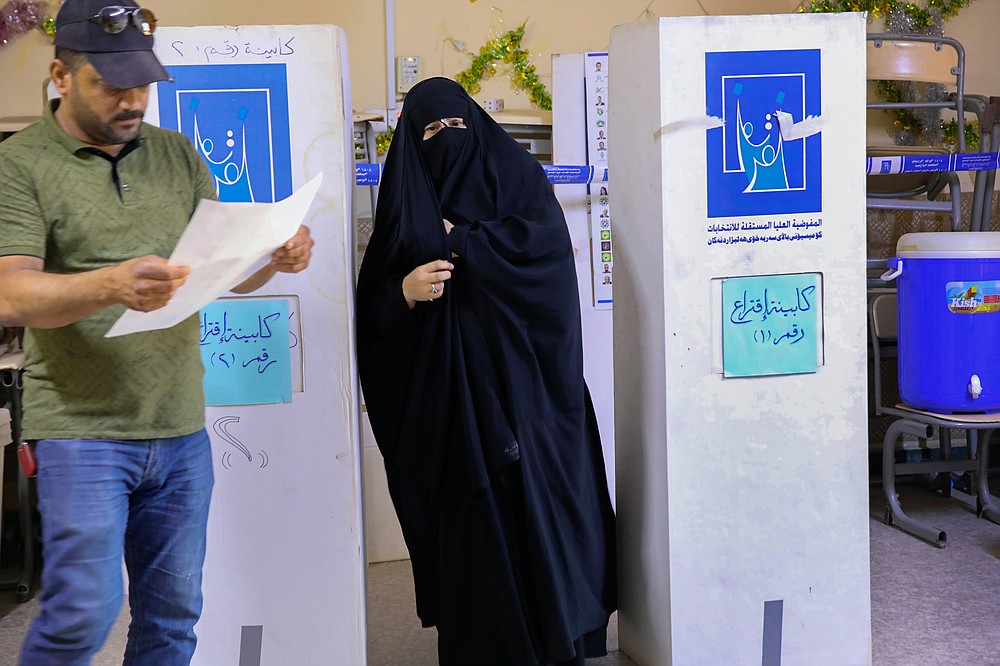 People cast their votes during the parliamentary elections in Basra, Iraq, Sunday, Oct. 10, 2021. Iraq closed its airspace and land border crossings on Sunday as voters headed to the polls to elect a parliament that many hope will deliver much needed reforms after decades of conflict and mismanagement. (AP Photo/Nabil al-Jurani)