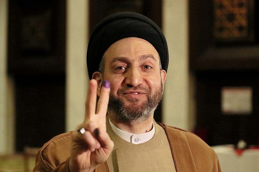 Ammar al-Hakim, leader of the Hikma political block, shows a v-sign with his ink-stained finger during the parliamentary elections in Baghdad, Iraq, Sunday, Oct. 10, 2021. Iraq closed its airspace and land border crossings on Sunday as voters headed to the polls to elect a parliament that many hope will deliver much needed reforms after decades of conflict and mismanagement. (AP Photo/Khalid Mohammed)