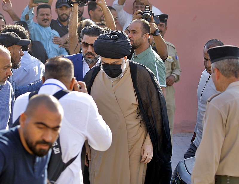 Populist Shiite cleric Muqtada al-Sadr, center, arrives to a polling center to vote in the parliamentary elections in Najaf, Iraq, Sunday. Iraq closed its airspace and land border crossings on Sunday as voters headed to the polls to elect a parliament that many hope will deliver much needed reforms after decades of conflict and mismanagement. - AP Photo/Anmar Khalil