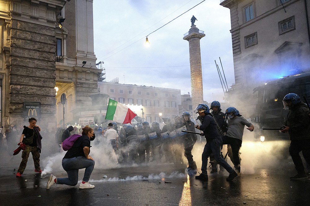 Demonstrators and police clash during a protest, in Rome, Saturday, Oct. 9, 2021. Thousands of demonstrators protested Saturday in Rome against the COVID-19 health pass that Italian workers, both the public and private sectors, must display to access their workplaces from Oct. 15 under a government decree. (Mauro Scrobogna/LaPresse via AP)