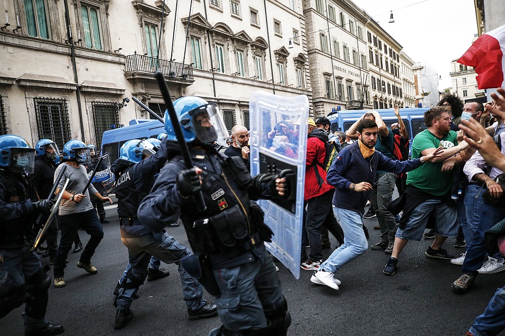 Police clashes with demonstrators during a protest, in Rome, Saturday, Oct. 9, 2021. Thousands of demonstrators protested Saturday in Rome against the COVID-19 health pass that Italian workers, both the public and private sectors, must display to access their workplaces from Oct. 15 under a government decree. (Cecilia Fabiano/LaPresse via AP)