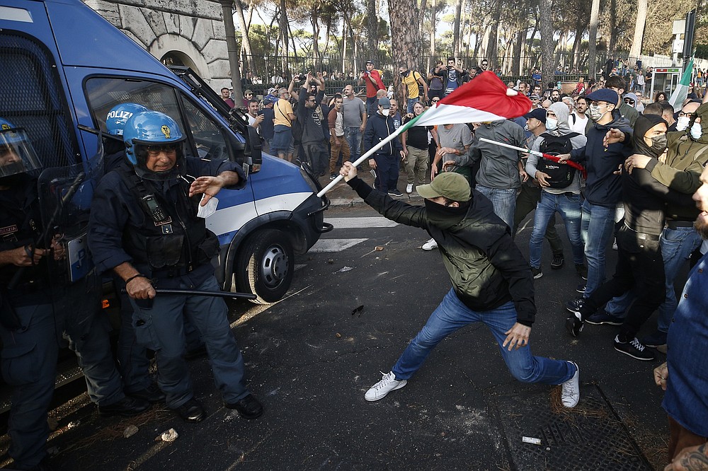 Police clashes with demonstrators during a protest, in Rome, Saturday, Oct. 9, 2021. Thousands of demonstrators protested Saturday in Rome against the COVID-19 health pass that Italian workers, both the public and private sectors, must display to access their workplaces from Oct. 15 under a government decree. (Cecilia Fabiano/LaPresse via AP)