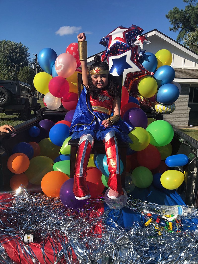 Zoe Zubiate, a second-grader from Siloam Springs, poses as Wonder Woman in her front yard Oct. 2 for what she thought would be a photo shoot. Instead, she was surprised by a welcome-home parade of Siloam Springs fire and police vehicles followed by a long line of family and friends. Zubiate recently returned home after receiving a heart and liver transplant at St. Louis Children's Hospital.
PHOTO PROVIDED BY CHRISTINA TRILLO