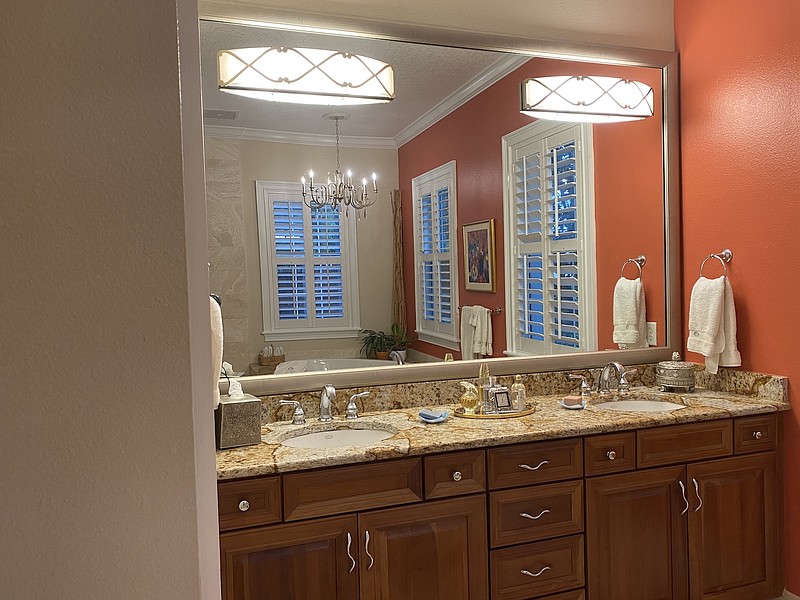 New light fixtures and a sleek, custom-cut frame from MirrorMate instantly updated and upgraded this master bathroom mirror. (Courtesy of Marni Jameson)