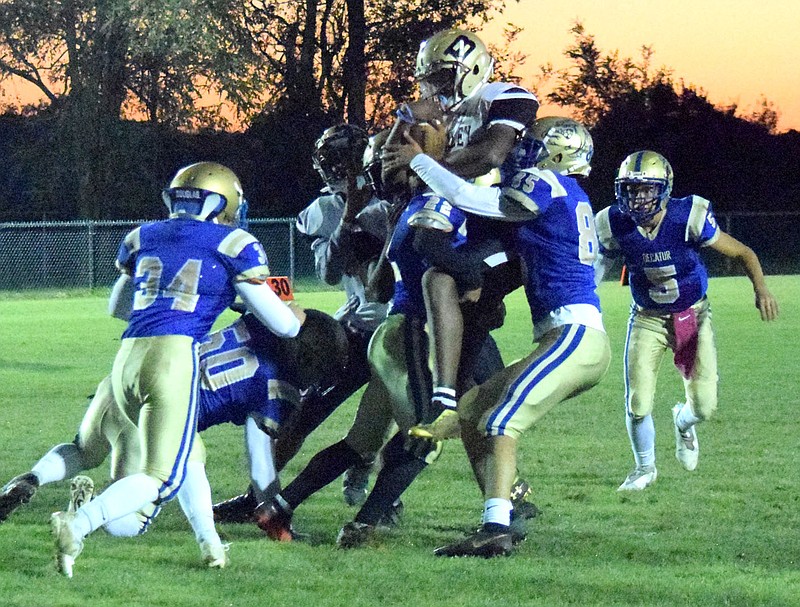 Westside Eagle Observer/MIKE ECKELS

A pack of Bulldogs literally pick up a Tiger running back prior to the entire group crashes down on the ground thus preventing a possible touchdown run during the Decatur-Brinkley football contest in Decatur Friday night. This play fired up the Bulldog defense enough that the Tiger advance stalled far short of the goal line.