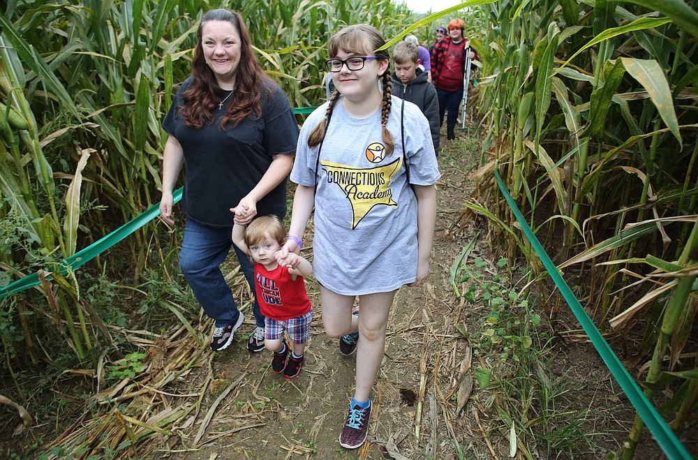 NWA Democrat-Gazette/DAVID GOTTSCHALK Alanna Updegraff (from right), a seventh grade student at Arkansas Connections Academy, walks Monday, September 24, 2018 with her brother Isaac, 2, and mother Stephanie through the Corn Maze during a fall celebration at Farmland Adventures in Springdale. The academy is an online school for students from kindergarten through 11th grade. Students, family and faculty gathered for an educational tour of the farm.
