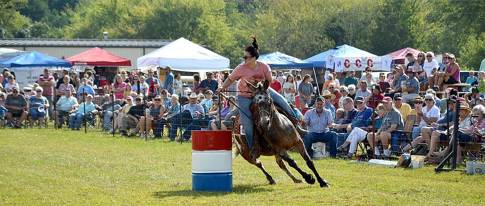 Colleen Born of Afton, Okla., and Comet round a barrel during the flag race Saturday.