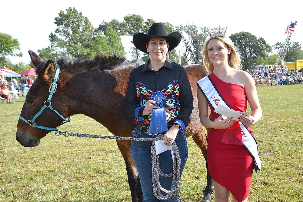 Halo, 25, shown by Heather Lutke won first place by clearing 48 inches in the 51 inches and over mule jump. Miss Pea Ridge 2021 Gabbie Fletcher presented the blue ribbon to Lutke.