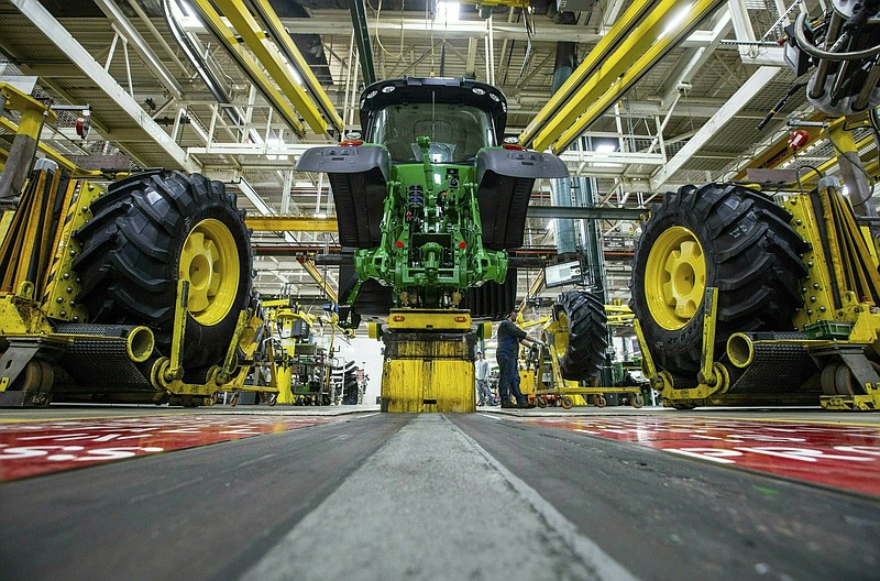 FILE - In this April 9, 2019, wheels are attach as workers assemble a tractor at John Deere's Waterloo, Iowa assembly plant. The vast majority of United Auto Workers union members rejected a contract offer from Deere &amp; Co. Sunday, Oct. 10, 2021 that would have delivered at least 5% raises to the workers who make John Deere tractors and other equipment. (Zach Boyden-Holmes/Telegraph Herald via AP, File)