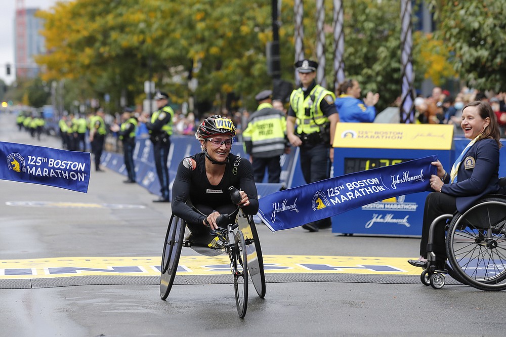 Manuela Schar, of Switzerland, breaks the tape to win the women's wheelchair division of the 125th Boston Marathon Monday, Oct. 11, 2021, in Boston. (AP Photo/Winslow Townson)