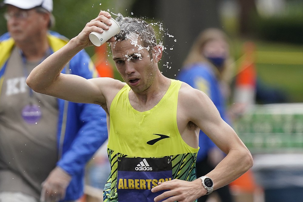 CJ Albertson, of Fresno, Calif., pours water on his head while running in the 125th Boston Marathon, Monday, Oct. 11, 2021, in Newton, Mass. (AP Photo/Steven Senne)