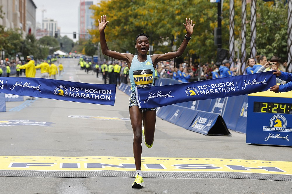Diana Kipyogei, of Kenya, hits the tape to win the women's division of the 125th Boston Marathon on Monday, Oct. 11, 2021, in Boston. (AP Photo/Winslow Townson)
