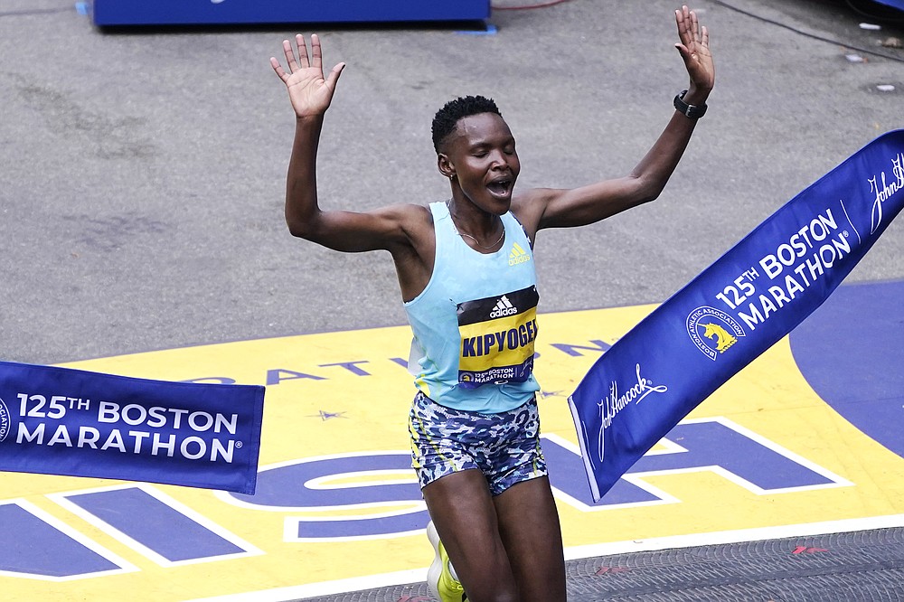 Diana Kipyogei, of Kenya, celebrates at the finish line after winning the women's division of the Boston Marathon in Boston, Monday, Oct. 11, 2021. (AP Photo/Charles Krupa)